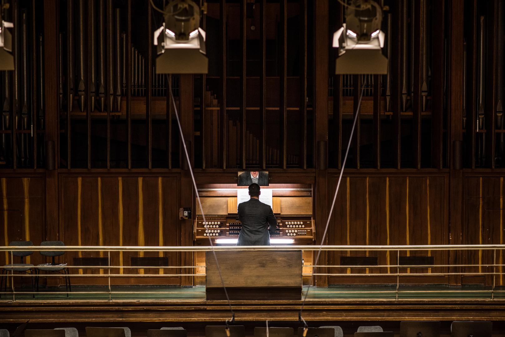 Ein Mann spielt an die Beckerath-Orgel im Großen Saal der Hochschule