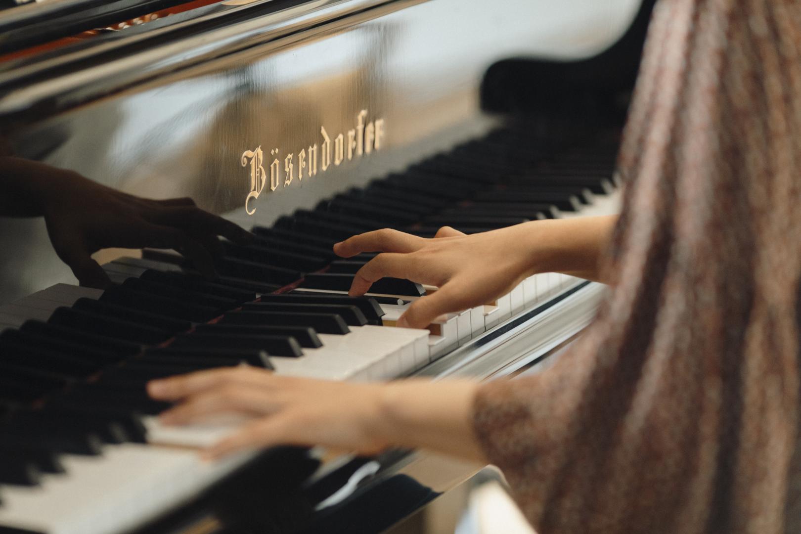 Nahaufnahme von Händen, die Klavier spielen.