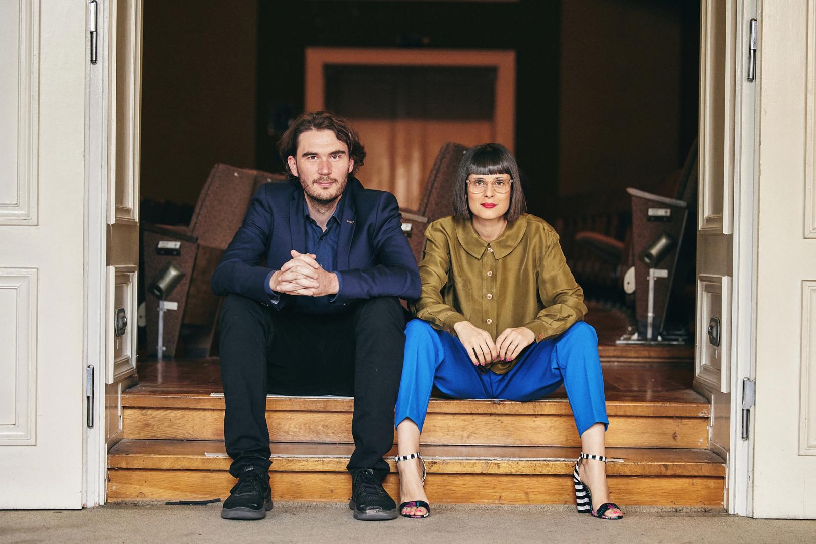 Jakob Arnold und Anica Happich sitzen nebeneinander auf einer Treppe.