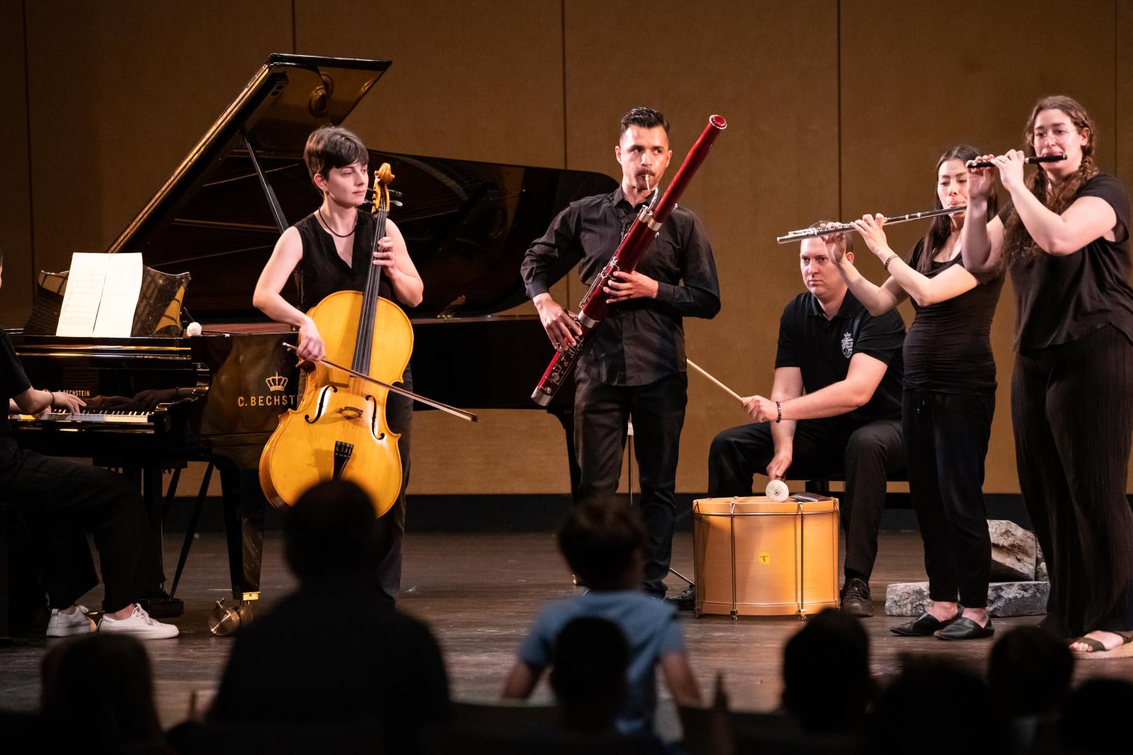 Ensemble aus fünf Musiker*innen bei einem Kinderkonzert auf der Bühne.