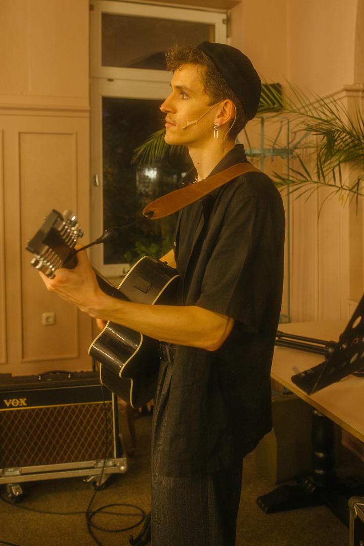 Ein Mann mit Gitarre in einem Café.