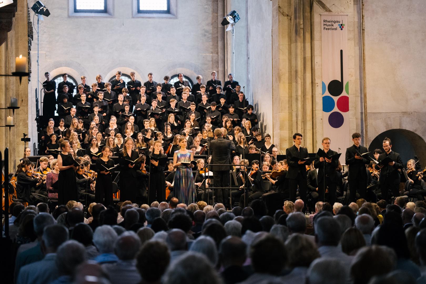 Blick auf volle Bühne mit Chor, Orchester und Solistenoktett im Kloster Eberbach