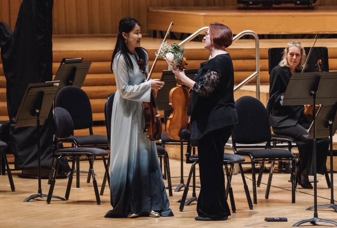 Xunyu Zhou wird ein Strauß Blumen überreicht