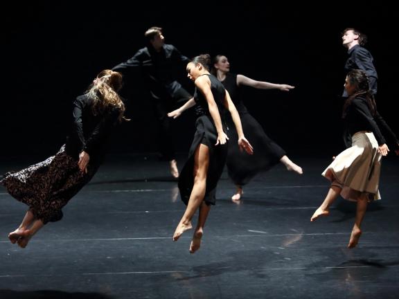 Mehrede tanzende Personen, die mitten im Sprung fotografiert sind und zu fliegen scheinen.