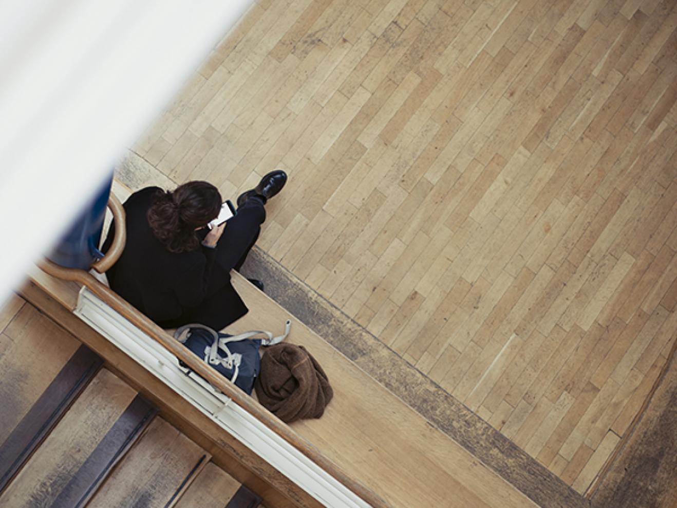 Person von oben im Foyer sitzend 