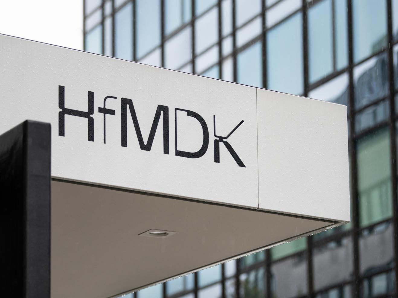 HfMDK-Schriftzug an einer Fassade im Regen.