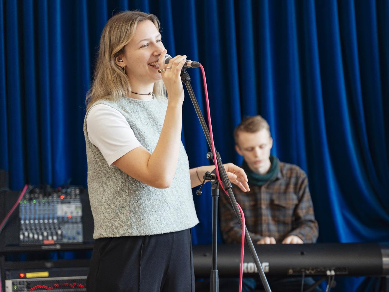 Die Frontsängerin von Groovedivision singt bei der Probe ins Mikrofon.